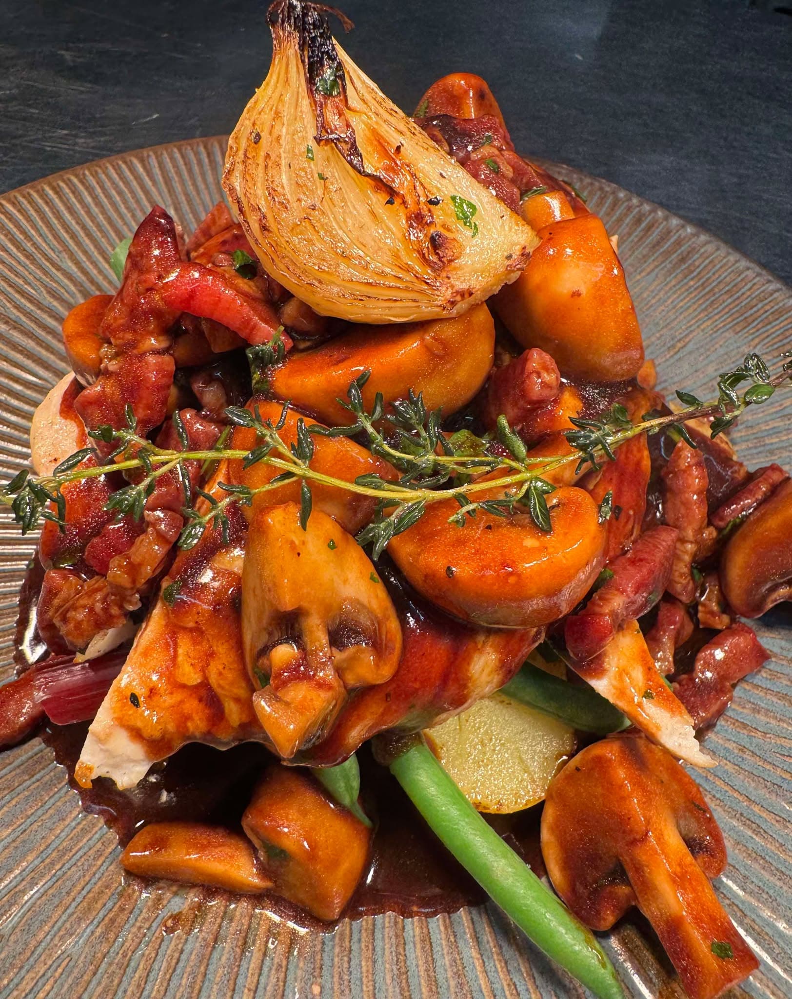 Roasted vegetables with chorizo, a whole roasted onion, tomatoes, potatoes and thyme