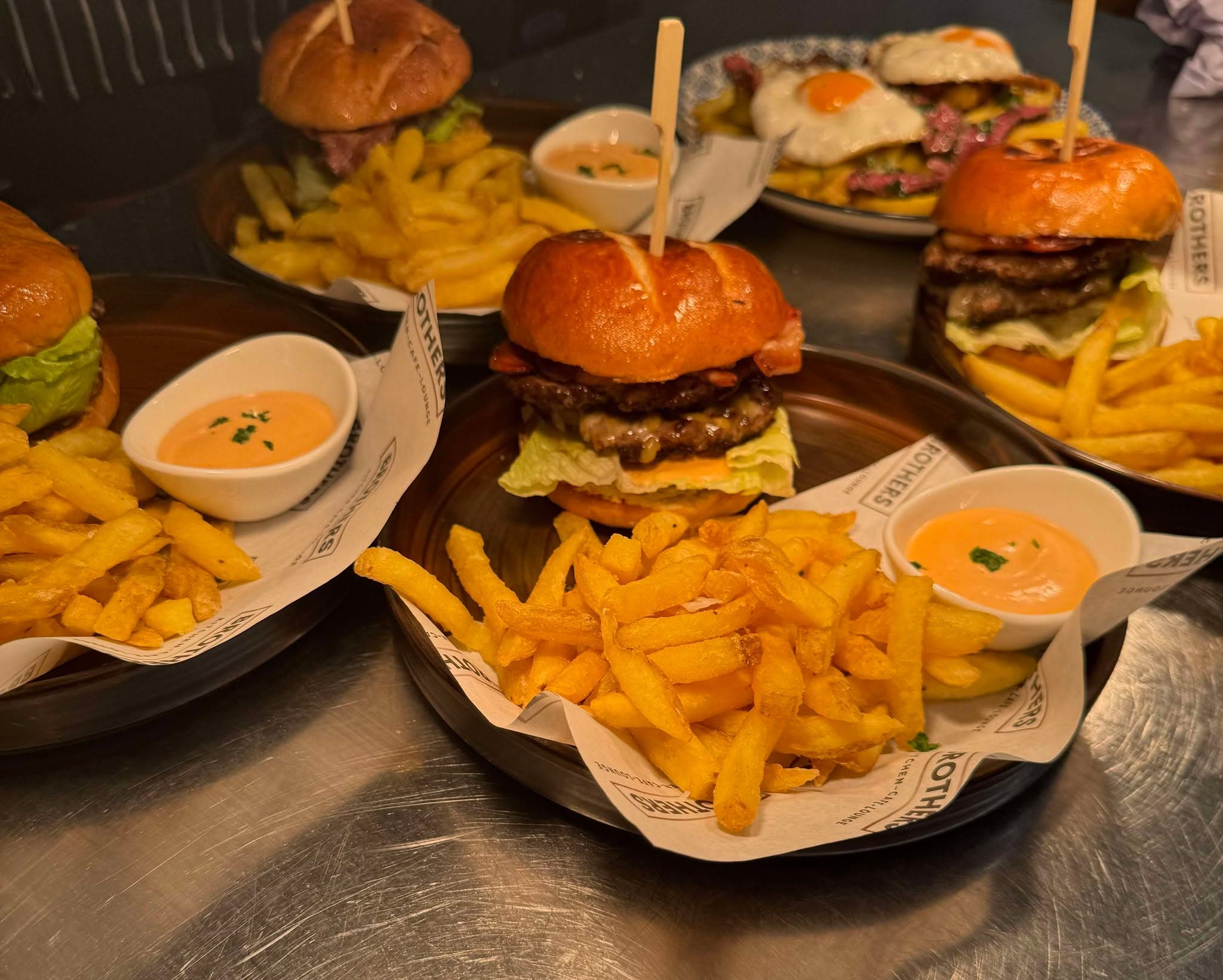 A sharing platter of miniature burgers, house fries and pots of dip