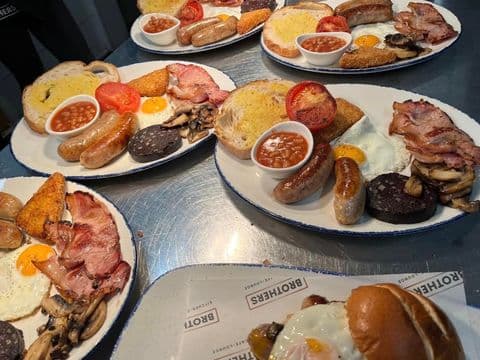 A table laid with several full English breakfasts on Brothers-branded paper